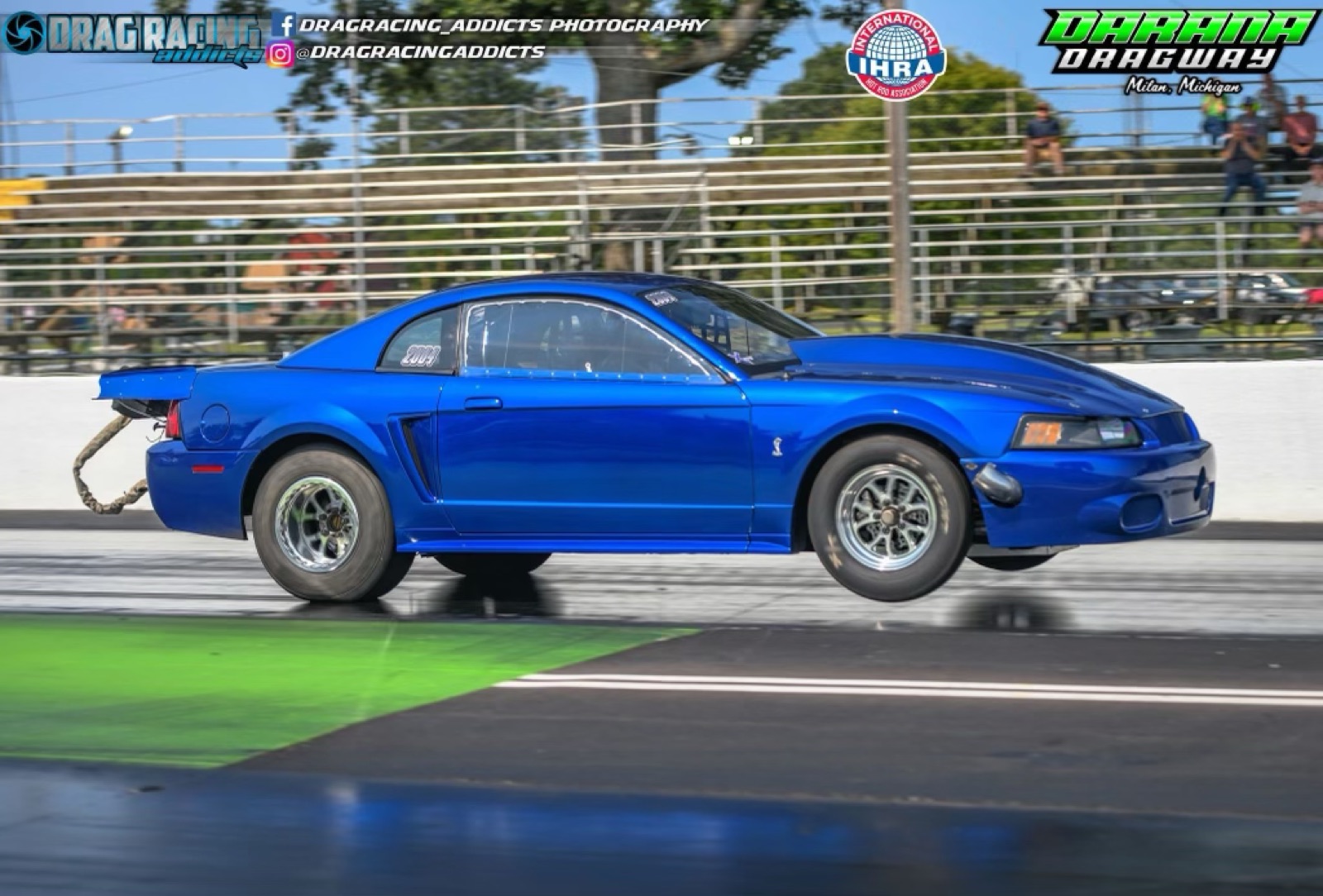 Adam Bastarache's blue SVT Cobra Mustang pulling the front wheels at the drag strip