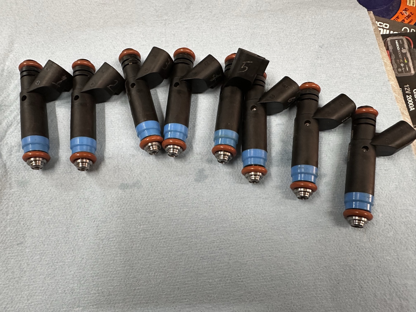 The same eight Siemens injectors after cleaning, with fresh Viton O-rings installed